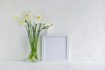 Mockup with a white frame and white daffodils