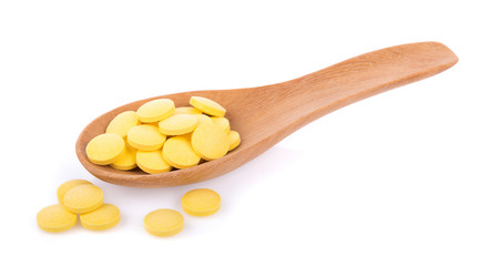 pills in spoon isolated on white background