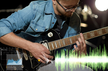 Obraz premium close up of musician playing guitar at studio
