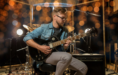 Obraz premium man playing guitar at studio rehearsal