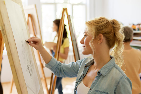 woman with easel drawing at art school studio