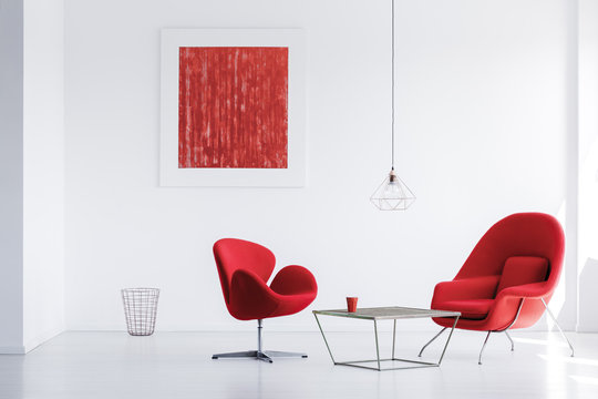 Designer red armchairs at table