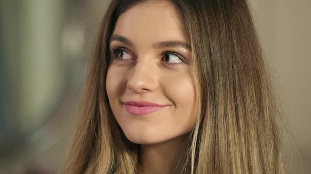 Face sensual woman with beautiful long hair touching skin on neck, biting sensual lips and sexy looking into camera close up