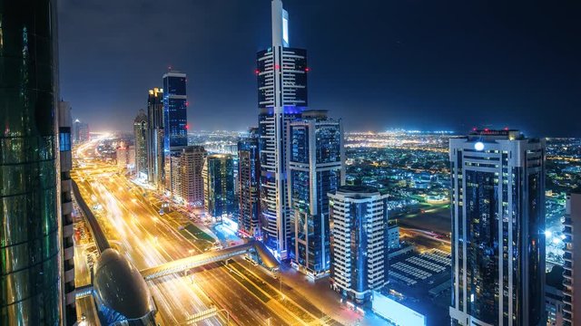 Spectacular nighttime skyline of Dubai. UAE. Aerial view of skyscrapers, highways and metro station. 4K time lapse. Colourful travel background.