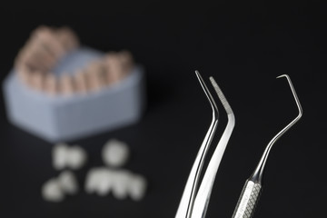 Dental tools with zircon dentures on a black background - Ceramic veneers - lumineers