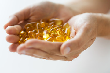Fototapeta premium hands holding cod liver oil capsules