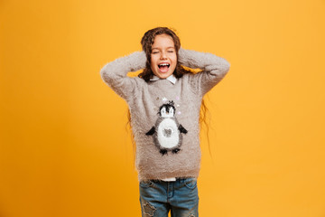Fototapeta premium Excited screaming little girl child covering ears with hands.