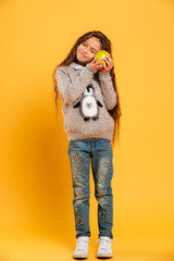 Obraz premium Smiling little girl child holding apple in hands.