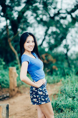 Naklejka premium Asian young beautiful woman in a blue T-shirt on a cliff of a mountain in the fog