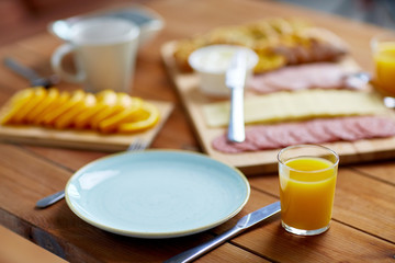 plate and glass of orange juice on table with food