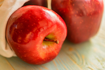 Red juice ripe apples on wooden background