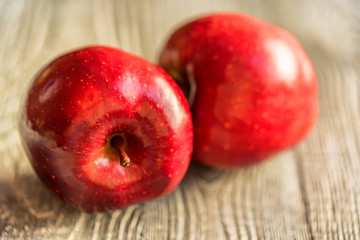 Red juice ripe apples on wooden background