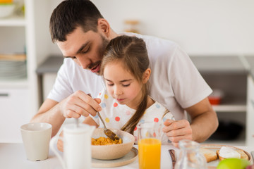Obraz na płótnie Canvas happy family eating flakes for breakfast at home