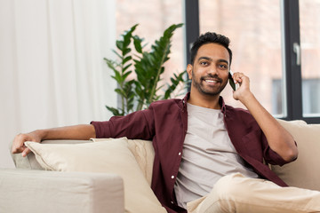 happy man calling on smartphone at home