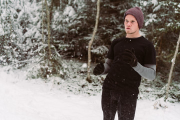 Fototapeta na wymiar Young man shadow boxing in a forrest in Austria in the winter