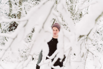 Young man shadow boxing in a forrest in Austria in the winter