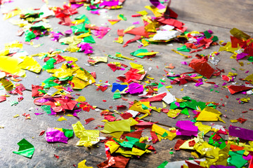 Fototapeta na wymiar Colorful confetti on wooden table. Party concept. Top view 