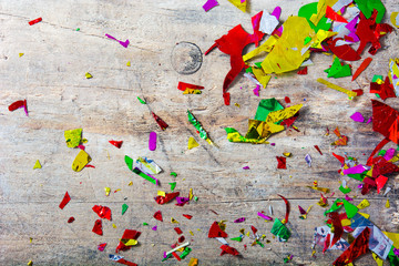 Colorful confetti on wooden table. Party concept. Top view 