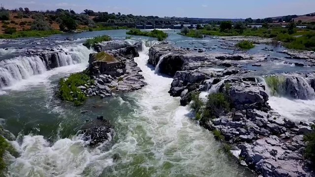 Aerial shot of a fast moving river with waterfalls