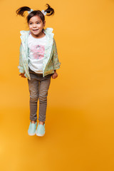 Naklejka premium Cheerful little girl child jumping isolated