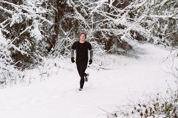 Young man running in the snow in Austria