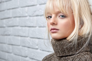 Cropped close up shot of an attractive young woman in a warm woolen sweater looking to the camera copyspace home seasonal winter coziness relaxation weekend enjoyment.