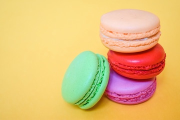 Cake macaron or macaroon isolated on yellow background, sweet and colorful dessert.Pastel