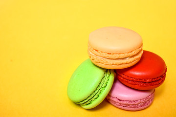 Cake macaron or macaroon isolated on yellow background, sweet and colorful dessert.Pastel