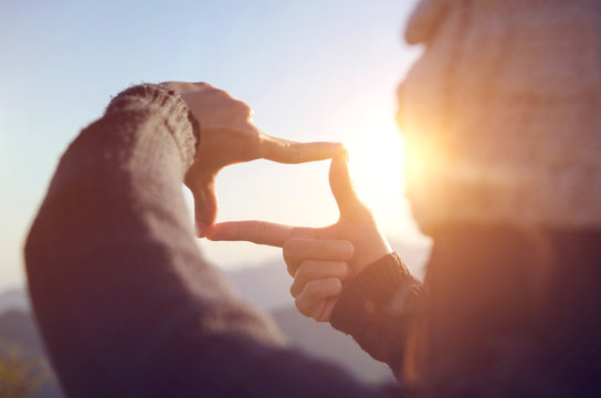 Close up of woman hands making frame gesture with sunrise on moutain, Female capturing the sunrise, Future planning, sunlight outdoor. © oatawa