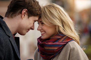 Waist up portrait of lovely playful couple looking right into eyes expressing curiosity and happiness