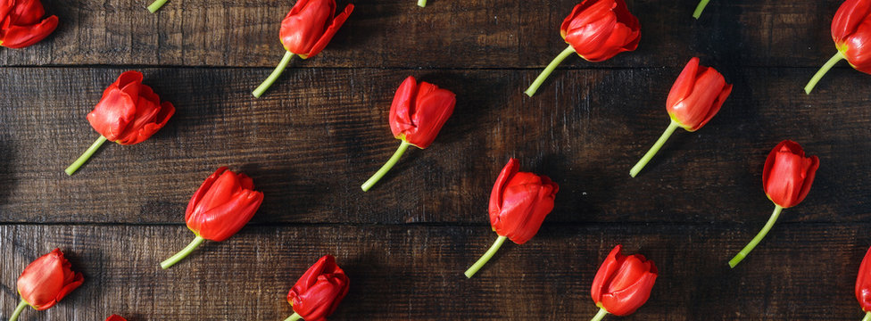 set of red tulips on dark wooden table