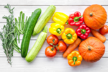 Base of healthy diet. Vegetables pumpkin, paprika, tomatoes, carrot, zucchini on white wooden background top view