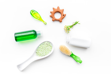 Soft bath cosmetics for kids with chamomile. Bottles, spa salt, tooth brush and toy on white background top view