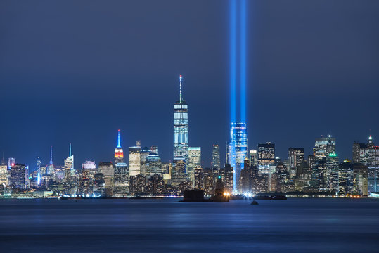 Fototapeta The two beams of the Tribute in Light with skycrapers of Lower Manhattan at night from New York Harbor. Financial District, New York City