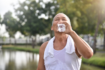 Asian senior male drinking water.