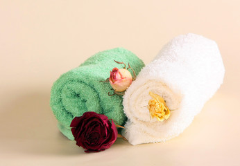 Obraz na płótnie Canvas Terry towel with dry roses. Decoration of the spa salon. Personal hygiene items and flowers. Horizontal image.