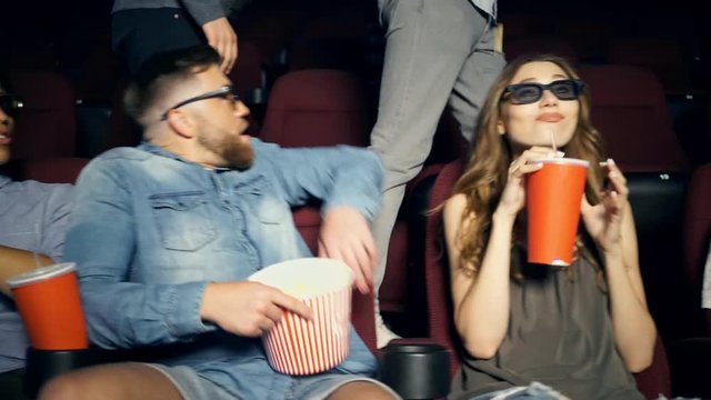 Displeased young multiethnic audience in 3d glasses watching film and shocked beacause of rude spectators in cinema