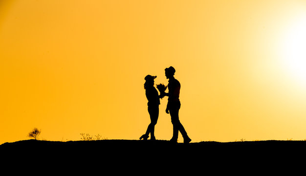 young couple silhouette at sunset