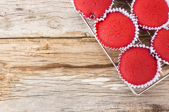 Red Velvet Cupcake On Baking Rack Over Wood Background. Top View With Copy Space.