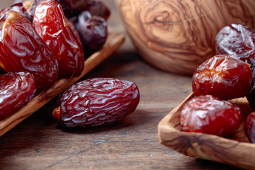 Juicy dates on wooden table .