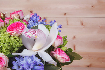 Bouquet of flowers on a light wooden background. Place for text.