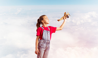 Concept of careless happy childhood with girl dreaming to become pilot