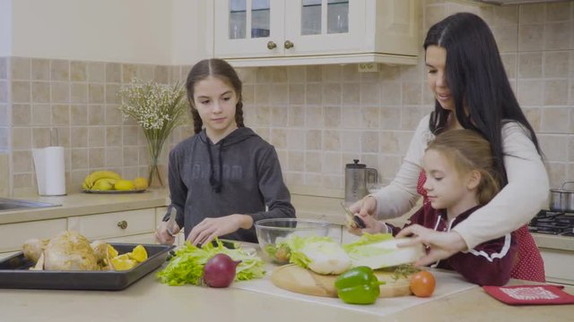 Daughters help mother to cook the dinner