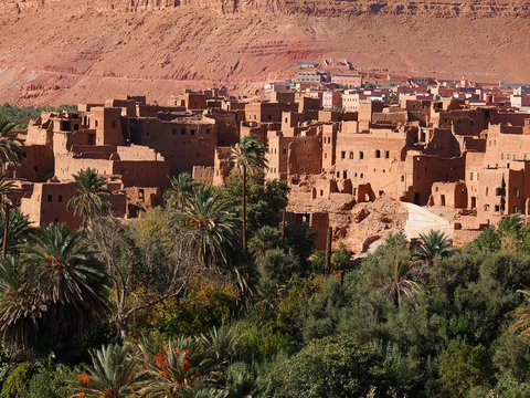 The moroccan town near Tinghir consisting of the clay made adobe kasbahs between gorgeous brown high Atlas mountains (stone desert in the canyon Gorge du Dades) and a huge oasis - Africa, Morocco