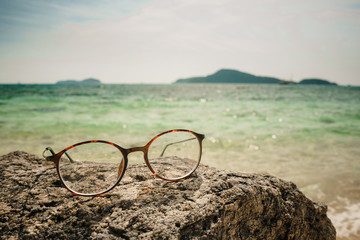 Fototapeta na wymiar Glasses for vision lie on a stone, on a tropical island beach.