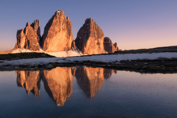 Fototapeta na wymiar Le Tre cime di Lavaredo si rifletto al tramonto in un laghetto