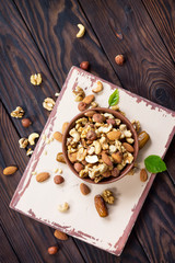 Mix of dried fruits and nuts on a wooden background. The concept of a healthy dessert. Top view with copy space.