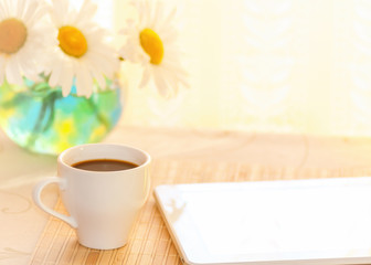 morning coffee and a tablet at breakfast, chamomile in a vase on the table, filter applied