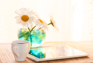 morning coffee and a tablet at breakfast, chamomile in a vase on the table, filter applied