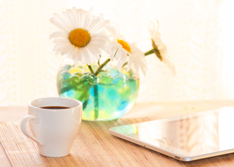 morning coffee and a tablet at breakfast, chamomile in a vase on the table, filter applied